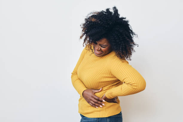 istock Woman grimacing while struggling with backache against white background 1306355571