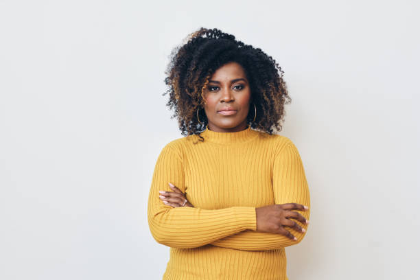 retrato de una hermosa mujer afroamericana sonriente de pie con los brazos cruzados - stern fotografías e imágenes de stock