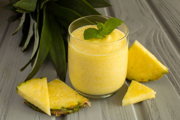 istock Smoothie with pineapple on the gray wooden background 1306356236