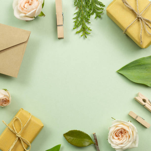 istock Gift boxes, rose, fresh leaf on green background. anniversary concept. flat lay, top view, copy space 1306356359
