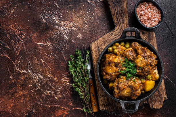 Beef oxtails stew with wine and vegetables in a pan. Dark background. Top view. Copy space Beef oxtails stew with wine and vegetables in a pan. Dark background. Top view. Copy space. stew stock pictures, royalty-free photos & images