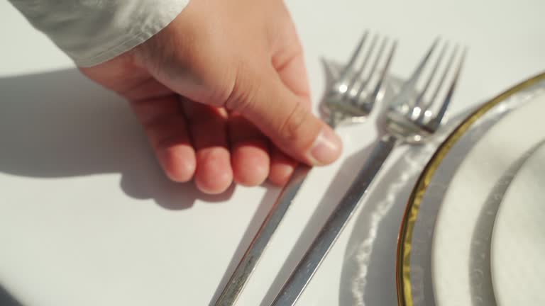 A hand serves a wedding table with fork