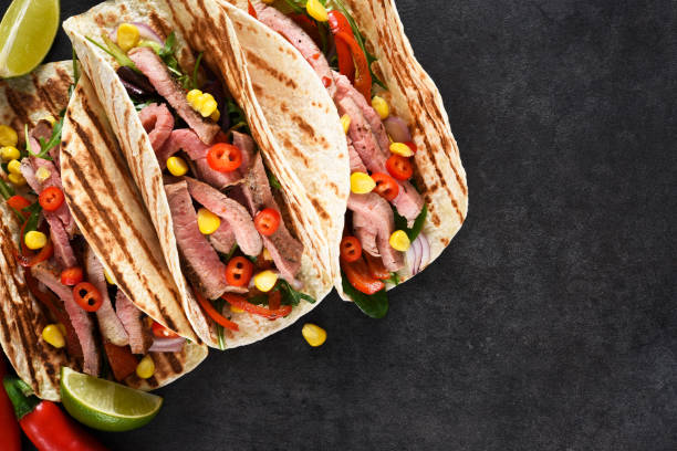 istock Mexican tacos with guinea, pepper and corn. Traditional Mexican dish. 1306359655