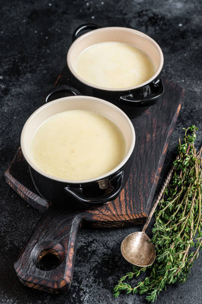 istock Potato cream soup in bowls on kitchen table. Black background. Top view 1306359806
