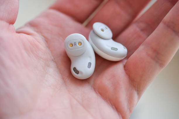 istock Wireless white in-ear headphones in hand, isolate 1306361041