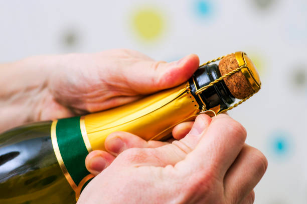 mans ręce otwierają butelkę szampana alkoholu i napoju wina na imprezie uroczystości. mężczyzna otwiera butelkę szampana. - champagne flute jubilee champagne wine zdjęcia i obrazy z banku zdjęć