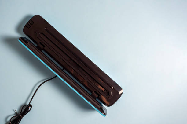 istock close-up of an open vacuum packer isolated on a bright blue background. A machine for preserving the freshness of products. Flat lying, top view. 1306365700