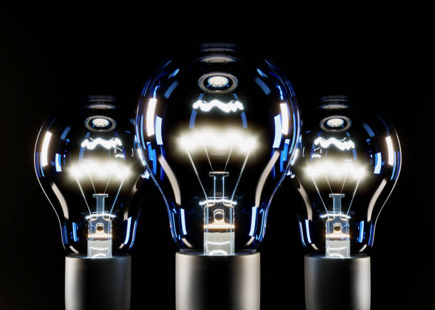 istock Three blue luminous incandescent bulbs on a black background. 3D rendering and 3D illustration. 1306365731