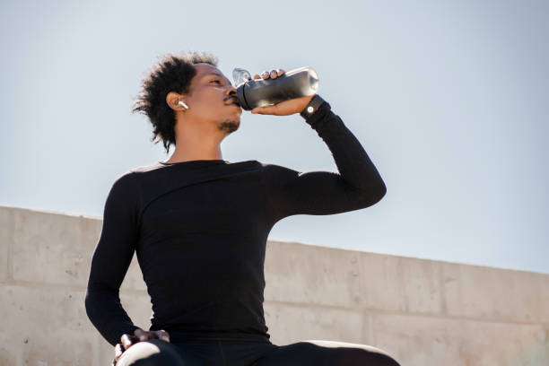 istock Athletic man drinking water after work out outdoors. 1306366100