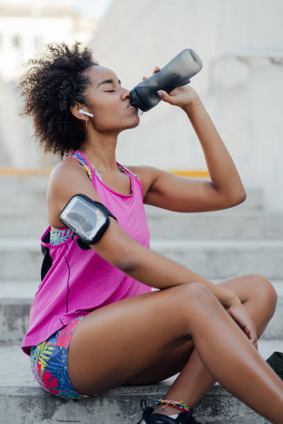 istock Athletic woman drinking water after work out outdoors. 1306366176