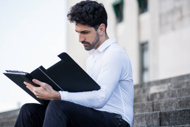 istock Business man reading files outdoors. 1306366880