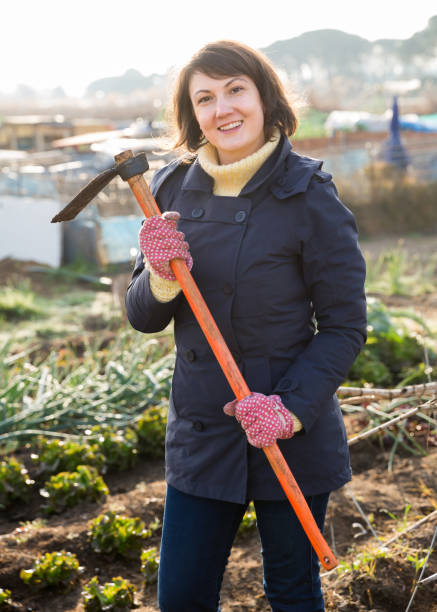 istock Woman gardener standing with hoe 1306366964
