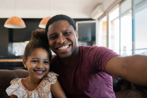 istock Daughter and father taking a selfie at home. 1306367035