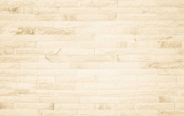 Empty background of wide cream brick wall texture. Beige old brown brick wall concrete or stone textured, wallpaper limestone abstract flooring/Grid uneven interior rock. Home decor design backdrop.