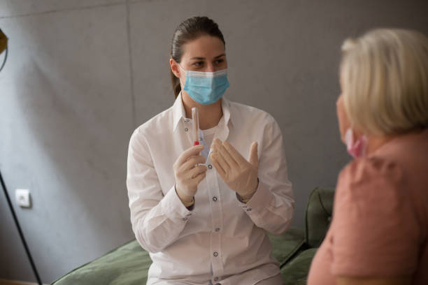 istock Young female docotr holding PCR test, while patient is sitting by her. 1306368107