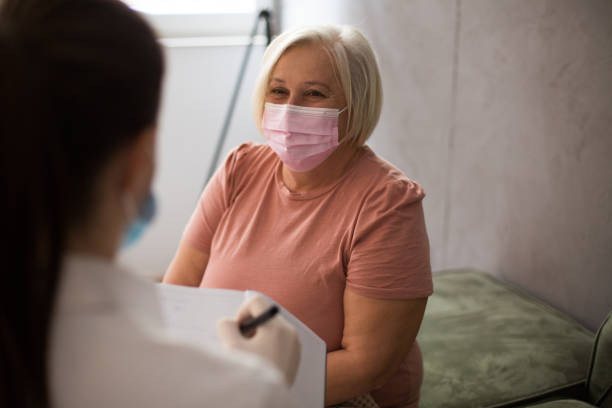 istock Senior woman visited by doctor during quarantine. 1306368214