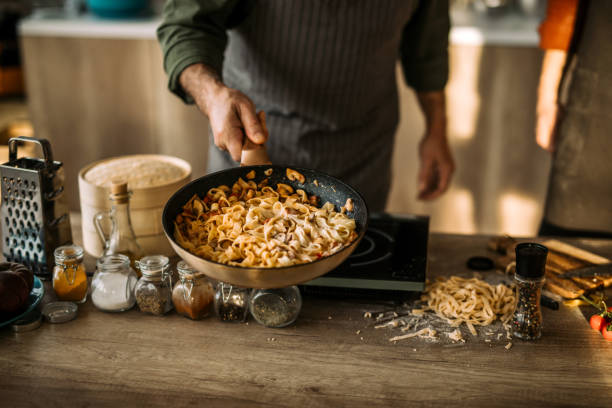 istock Senior chef in professional kitchen cooking fettuccine pasta 1306372500