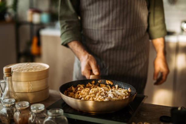 istock Senior chef in professional kitchen cooking fettuccine pasta 1306372536