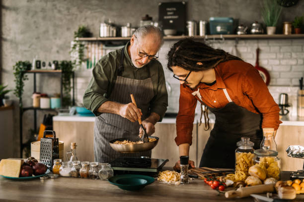 istock Young man learning cooking skills from an experienced chef. 1306372644