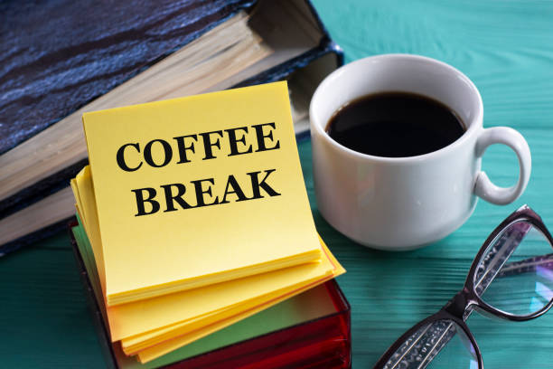Books, notebooks and coffee cup on wooden table in the outdoors