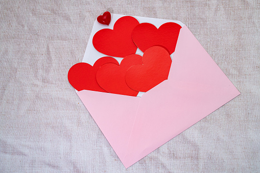 A pink envelope full of red hearts