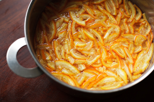 Preparation for making a small batch of homemade bitter orange marmalade in a domestic kitchen. Ingredients: Seville oranges (using the whole fruit, including peel and pips), Amalfi lemon juice and pips, preserving sugar, and water.