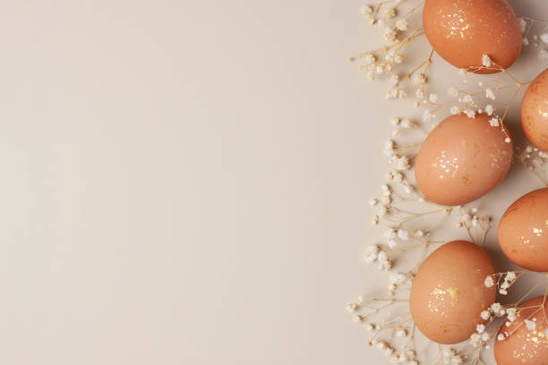 istock Easter eggs with flowers on pastel beige background. Flat lay, copy space. 1306373741