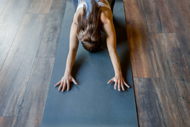 istock Woman stretching her back while doing yoga at the gym 1306374879