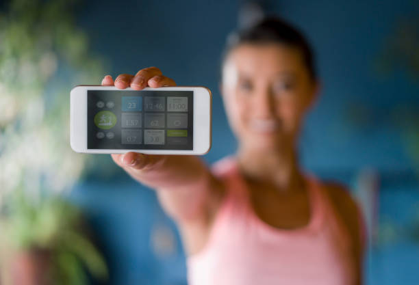 Latin American woman at the gym using her cell phone to track her progress in a session and holding it towards the camera