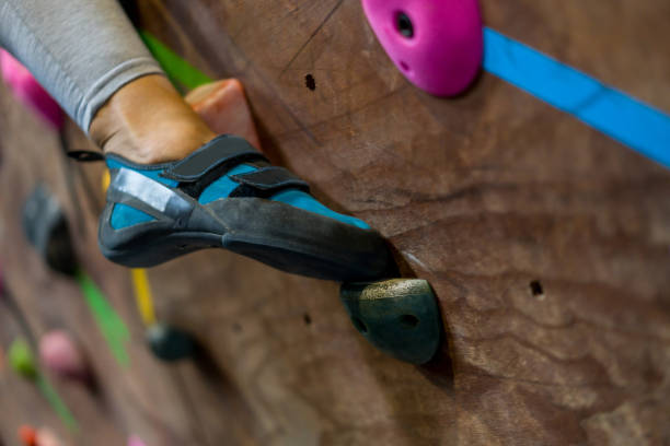 istock Climber wearing bouldering shoes while placing her feet on a rock 1306374936
