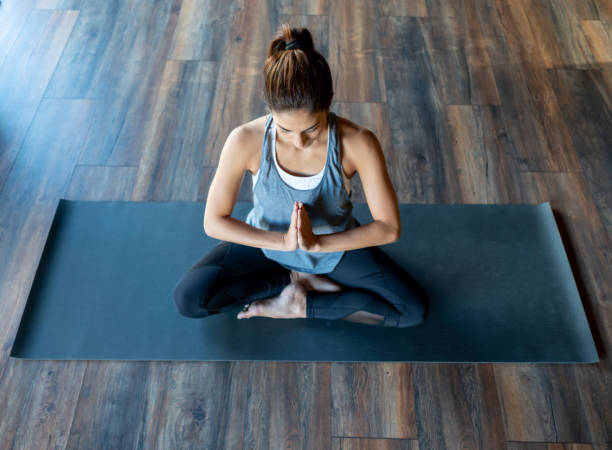 istock Peaceful woman meditating at a yoga studio 1306374967