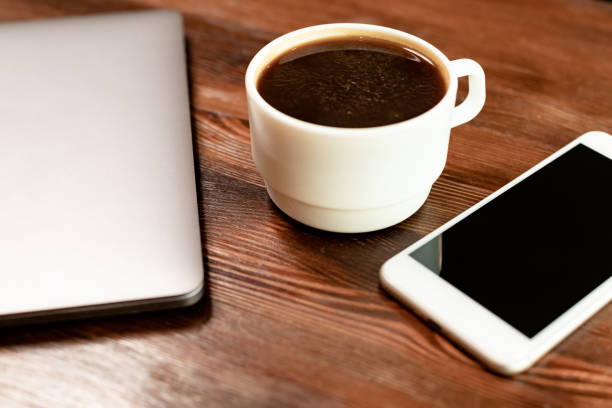istock Workspace with coffee, laptop and smartphone on wooden table 1306376168