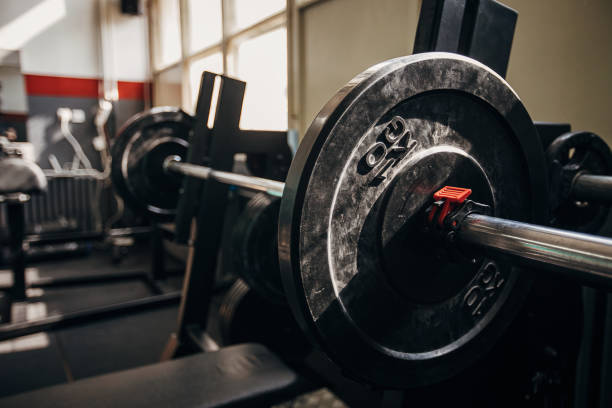 Weights on barbell Exercise equipment bench press and weights in empty gym. No people. barbel stock pictures, royalty-free photos & images