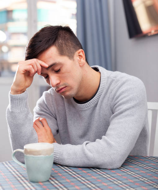istock Unhappy man tired of problems having headache indoors 1306377986
