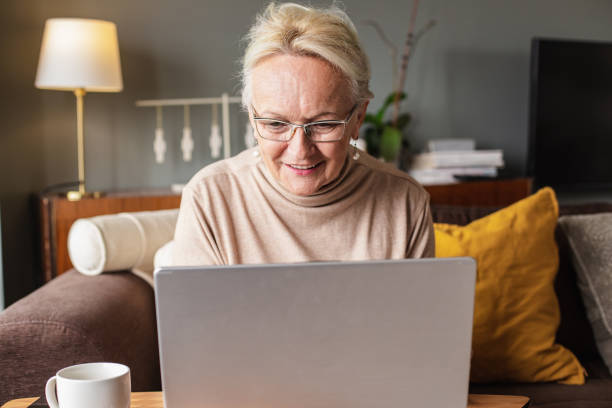 istock Senior woman is using laptop at home 1306378147