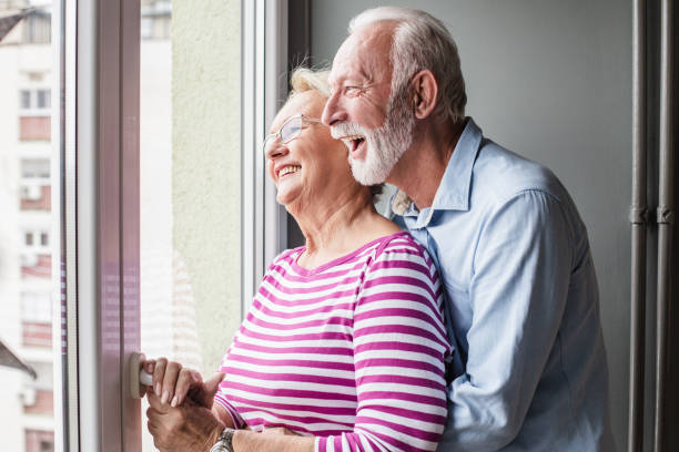istock Happy senior couple is looking through the window 1306378183