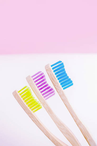 istock Yellow, pink and blue bamboo toothbrushes. Eco-friendly concept. Minimal, pink background. Copy space 1306379023