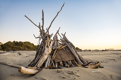 This photograph is of driftwood stacked on the beach at Bullards Beach State Park, Oregon at dusk.