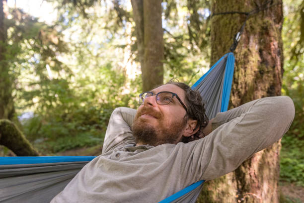 istock Smiling Caucasian Man Relaxing in Hammock in Washington State Park 1306379343