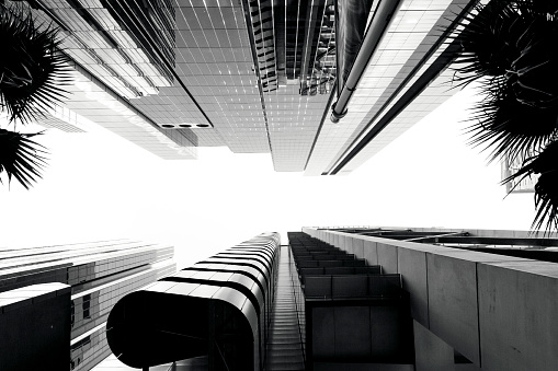 Black and white low angle view of modern office buildings, skyscrapers, sky background with copy space, full frame horizontal composition