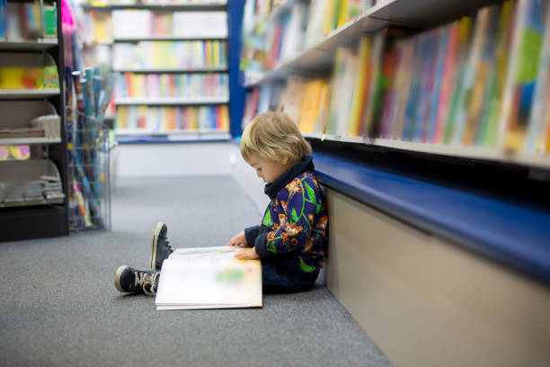 istock Adorable little boy, sitting in a book store 1306381130
