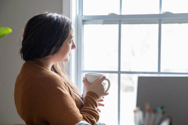 istock Mid adult woman deep in thought while working from home office 1306382469