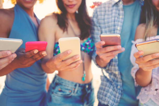 istock Group of multicultural friends using smartphone outdoors 1306383753