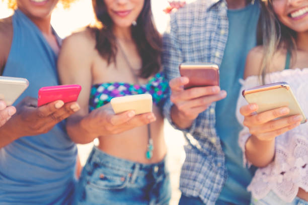 istock Group of multicultural friends using smartphone outdoors 1306383755