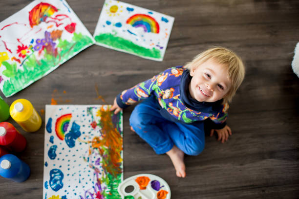 甘い幼児のブロンドの子供、男の子、色で絵を描き、指のプリントを作る - artists canvas indoors childhood small ストックフォトと画像