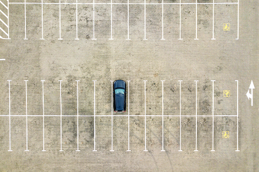 Top down aerial view of many cars on a parking lot of supermarket or on sale car dealer market.
