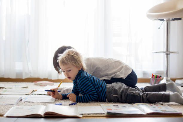 istock Child, doing school work on the floor at home while in quarantene 1306392808