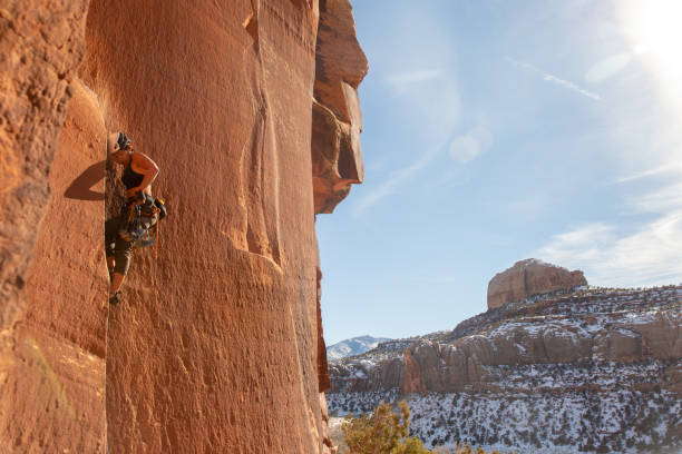 A female climber ascends the splitter crack Supercrack, in Indian Creek, UT.