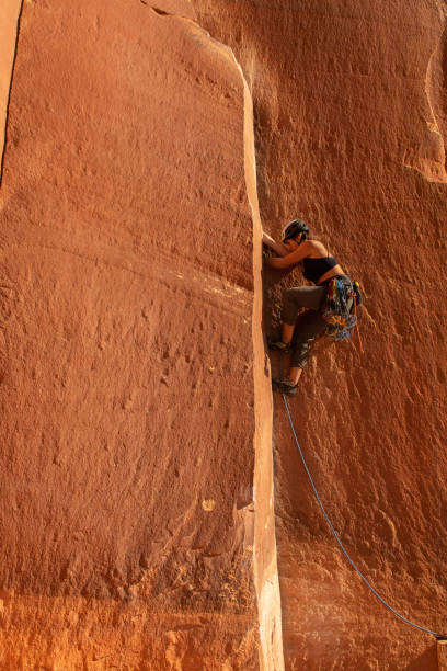 A female climber ascends the splitter crack Supercrack, in Indian Creek, UT.