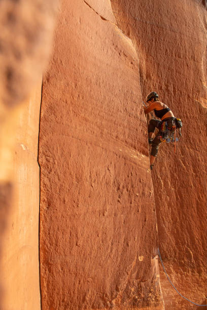istock Female climber scales sandstone crack climb 1306393004